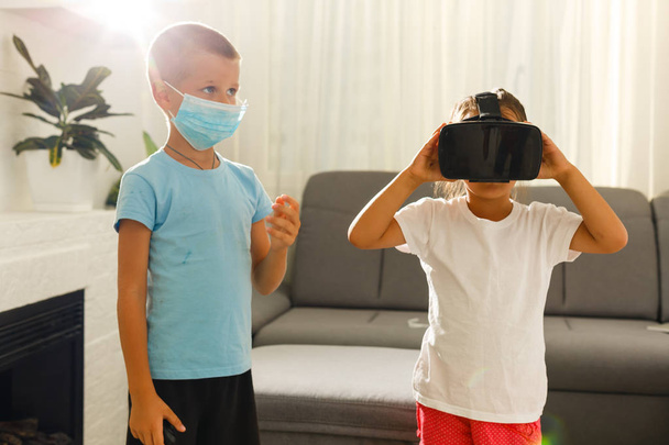 Bruder und Schwester mit Virtual-Reality-Headsets im Wohnzimmer - Foto, Bild