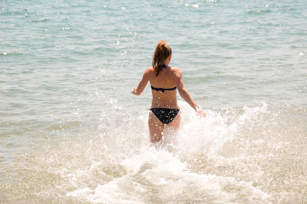 Девушка бежит в море в хороший летний день
. - Фото, изображение