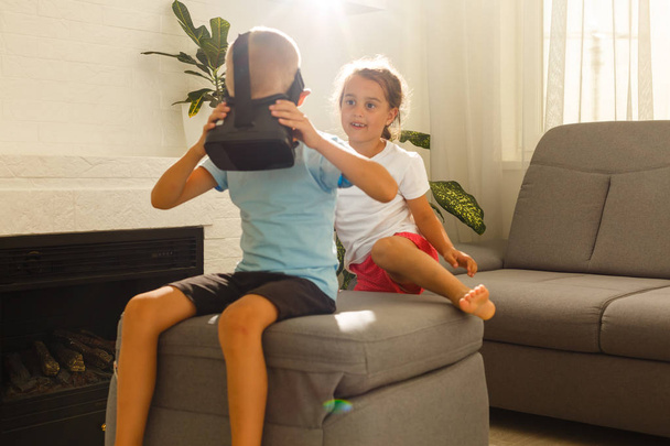 Brat i siostra za pomocą wirtualnej rzeczywistości zestawy słuchawkowe w salonie - Zdjęcie, obraz