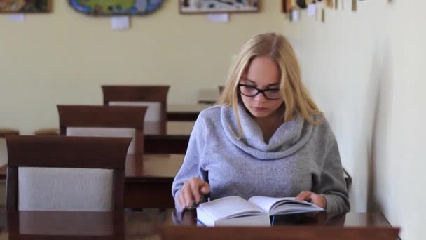 girl in the reading room reading a book - Felvétel, videó