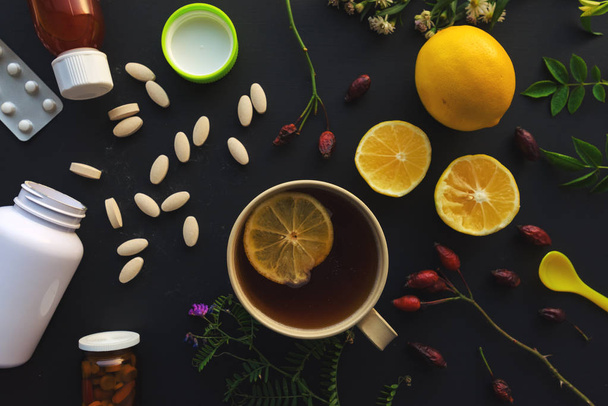 Herbal vs conventional medicine concept, cup of tea and lemon fruit or pills and medications - Фото, зображення