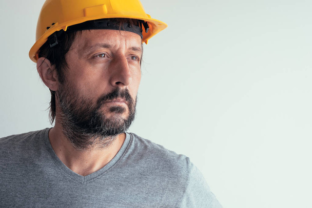 Portrait of serious thoughtful construction engineer isolated on bright background - Foto, afbeelding