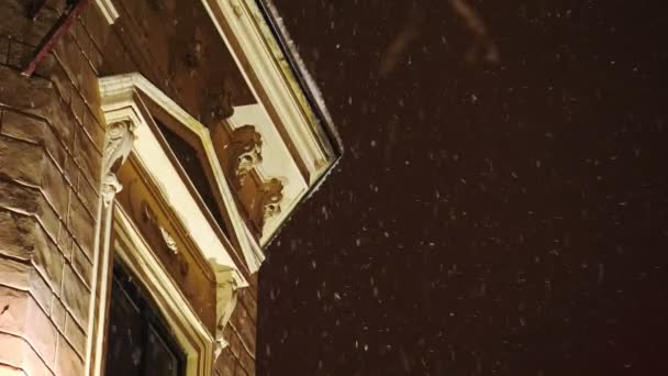 Χιονοπτώσεις στο φόντο του σπίτι στην πόλη - Πλάνα, βίντεο