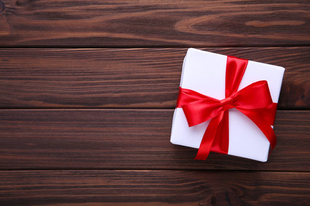 Gift presents box with ribbon on a brown wooden background. - Φωτογραφία, εικόνα