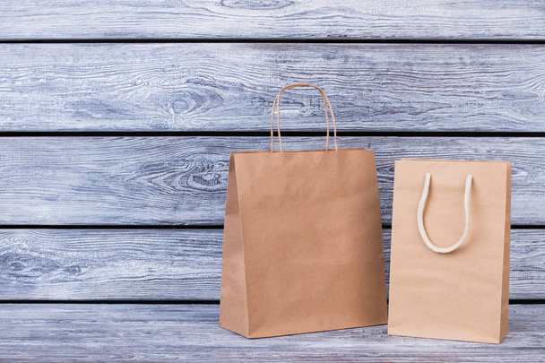 Brown paper shopping bags on wooden background. - Photo, image