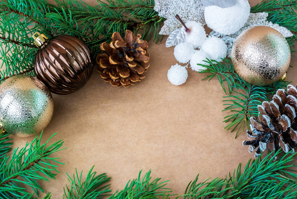 La photo est sous la forme d'un cadre de branches de pin de cônes et de jouets pour l'arbre de Noël. Au milieu de l'espace libre pour le texte du papier artisanal
 - Photo, image