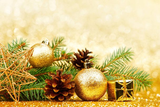 Christmas card with fir branch and decorations on golden gitter background - Fotografie, Obrázek