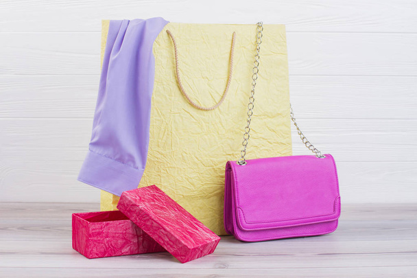 Shopping bag with female purchases on wooden background. - Photo, Image