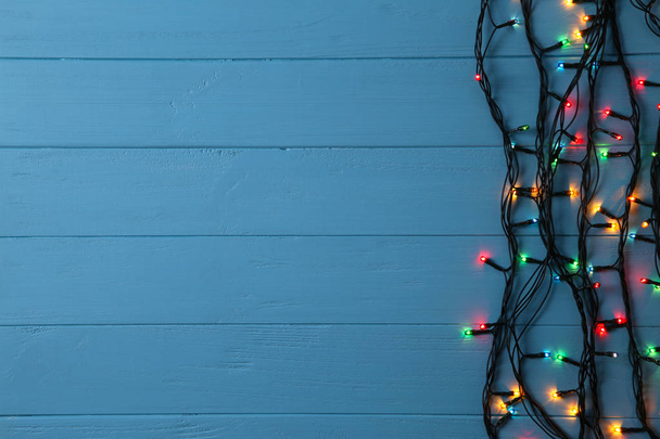 クリスマスの花輪は、青の背景、コピー領域に点灯します。クリスマスの組成 - 写真・画像