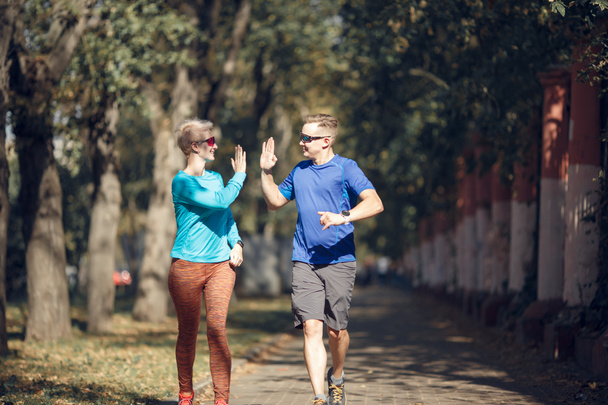 Picture of sporting man and woman doing handshake on morning jog - Foto, afbeelding