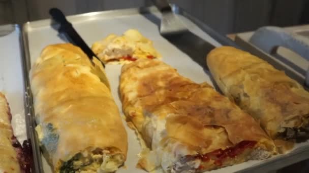 Sweet strudel and strudel with meat are on the baking sheet in the window - Footage, Video