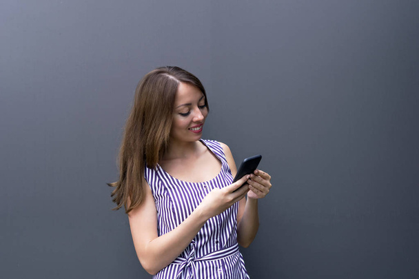 Wesoła dziewczyna uśmiechający się przy użyciu telefonu - Zdjęcie, obraz