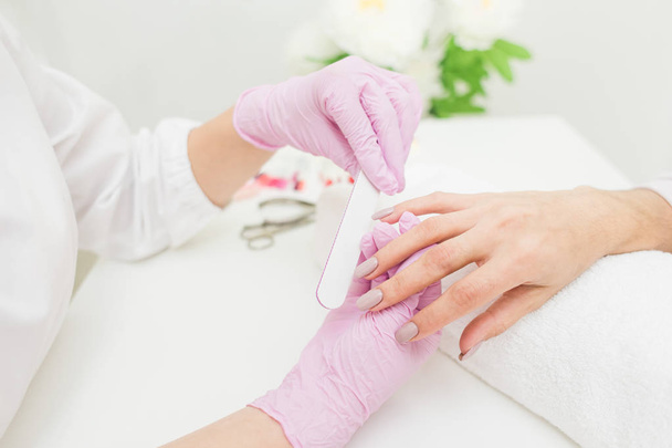 Young woman getting manicure in beauty salon. Close-up - Fotó, kép