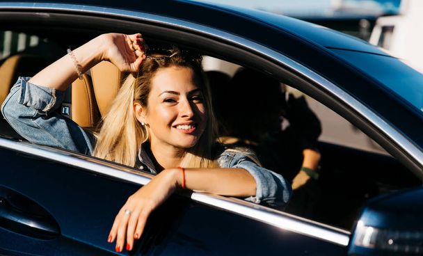 Image of side view of happy girl sitting in car - Fotó, kép