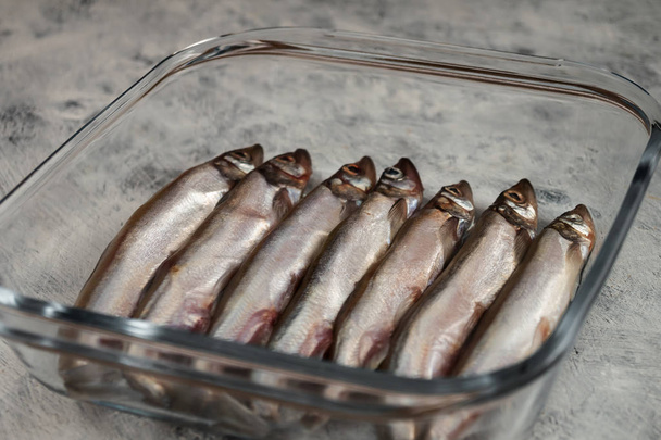 Syrové ryby malé na dno skleněné nádoby pro pečení. - Fotografie, Obrázek