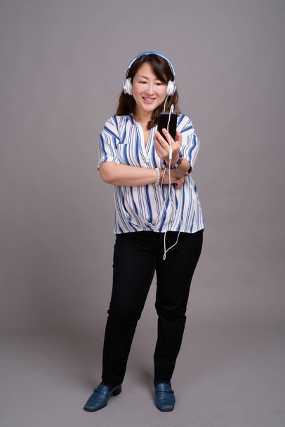 Портрет зрелой японской предпринимательницы в наушниках
 - Фото, изображение