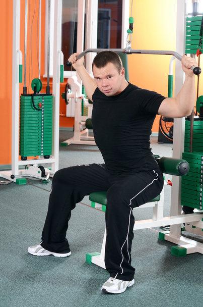 The man on training apparatus in sports club - Foto, Bild