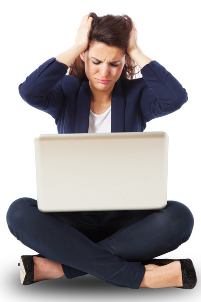 Stressed young businesswoman working on a laptop - Zdjęcie, obraz