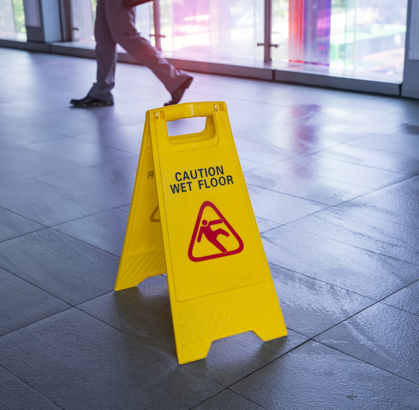 Yellow Caution wet floor sign on wet floor - 写真・画像