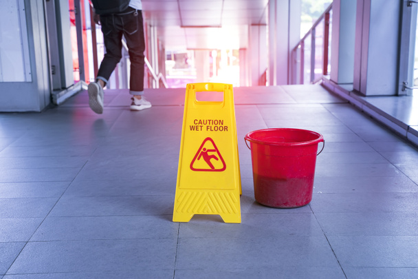 Желтый знак предупреждения о мокром полу на мокром полу
 - Фото, изображение