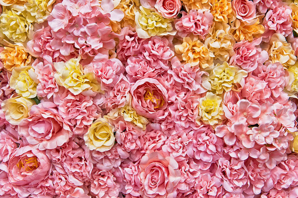 Beautiful multicolored artificial flowers background. flowers decor. - Фото, изображение