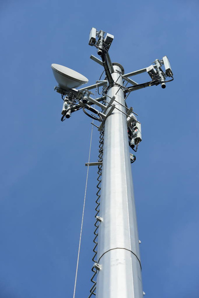 Ασύρματη κεραία επικοινωνίας με φωτεινό ουρανό. Πύργος τηλεπικοινωνιών με κεραίες με το μπλε του ουρανού. - Φωτογραφία, εικόνα