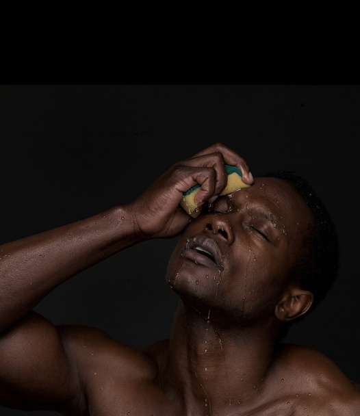 Afrikaanse Amerikaanse man wassen gezicht - Foto, afbeelding