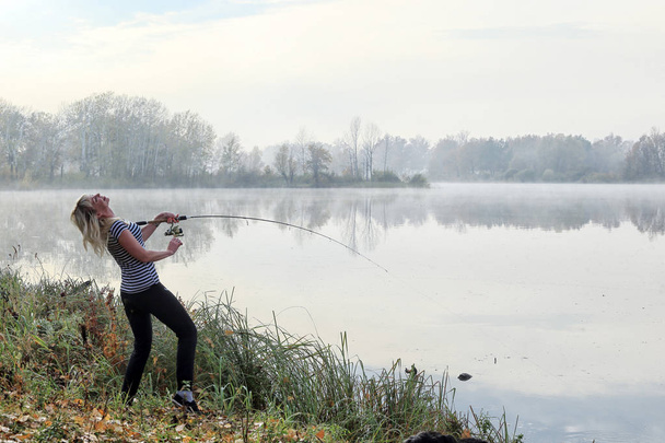 Girl fishing foggy autumn morning on the river - Fotoğraf, Görsel
