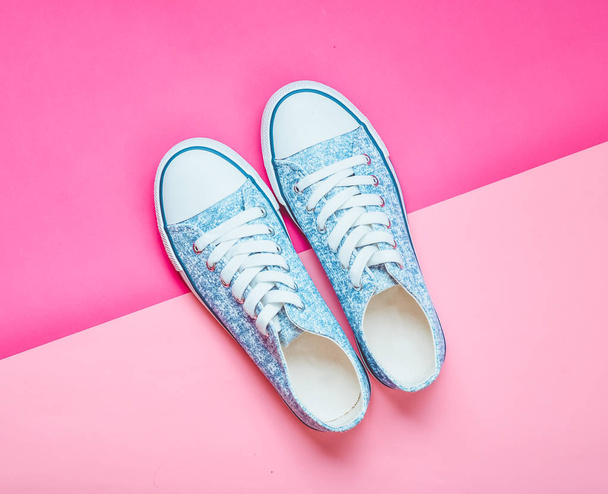 Классические женские кроссовки с белыми шнурками 80-х годов на розовом пастельном фоне. Вид сверху
. - Фото, изображение