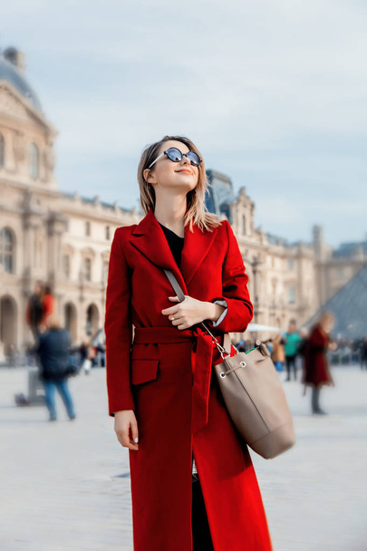 赤いコートと秋のシーズンにパリの通りのバッグでスタイル赤毛の女の子  - 写真・画像