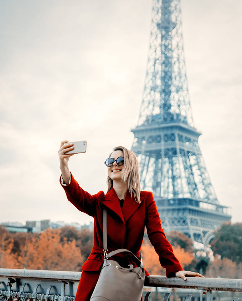 Mädchen in rotem Mantel machen ein Foto auf der Pariser Straße - Foto, Bild