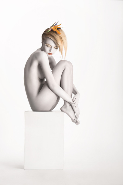 Fantasy. Harmony. Beauty Muse sitting over White Background. Bodyart - Platinum Painted Skin - Fotó, kép