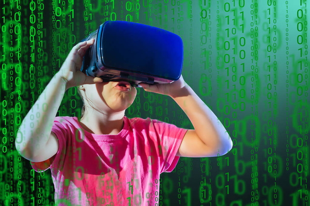 Chica joven que experimenta juego de auriculares VR en un fondo colorido. Niño usando un gadget de juego para la realidad virtual. Gafas futuristas a temprana edad. Tecnología virtual - Foto, Imagen