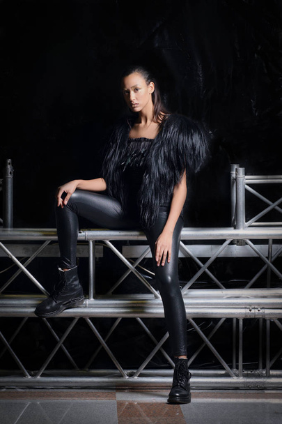 Pretty girl in fur vest and leather pants posing - Фото, изображение