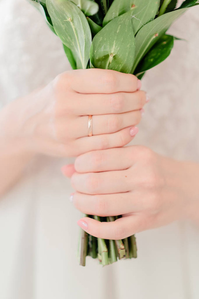 結婚式の花の女性両手は。結婚指輪と花嫁のドレス.  - 写真・画像