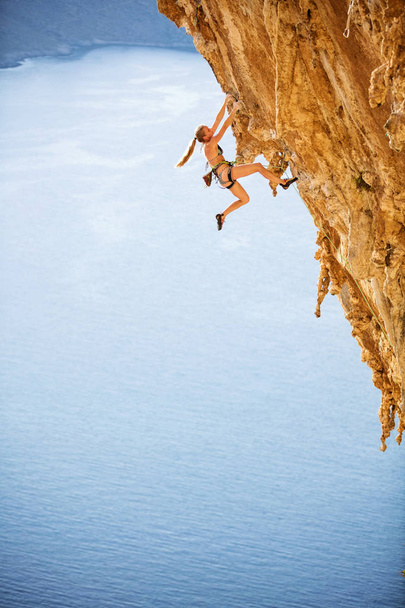 Joven escaladora en bikini en ruta desafiante en acantilado
 - Foto, Imagen