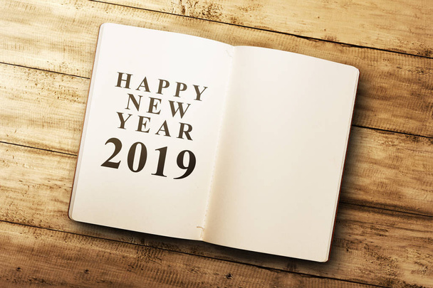 Opened book with new year message and empty space for copyspace on wooden table. Happy New Year 2019 - Foto, Imagen