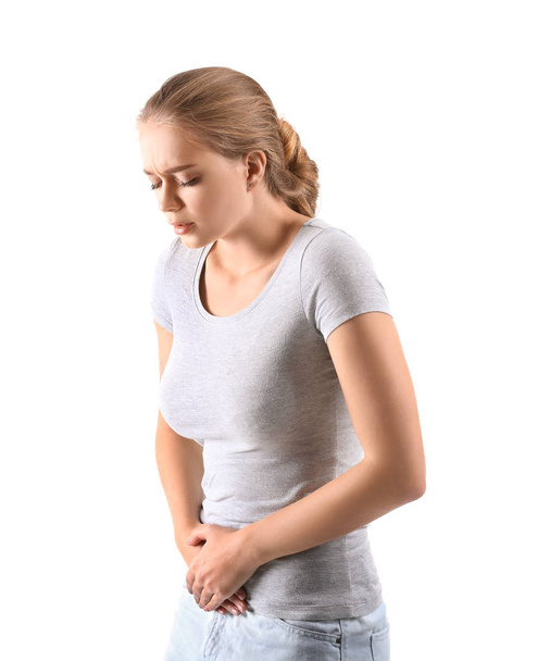Mujer joven que sufre de dolor abdominal sobre fondo blanco - Foto, imagen