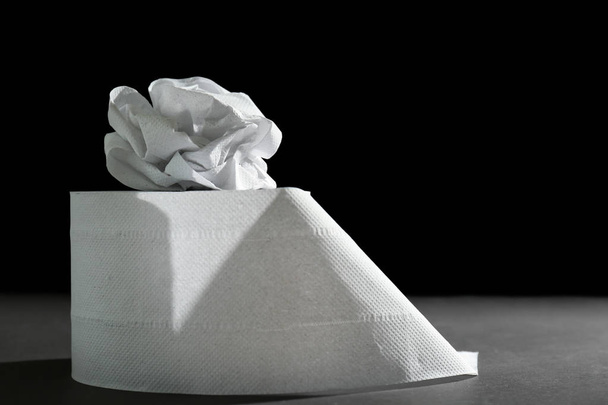 Rollo de papel higiénico sobre fondo oscuro
 - Foto, Imagen