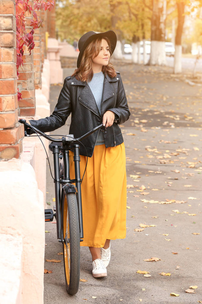 Beautiful young woman with bicycle outdoors - 写真・画像
