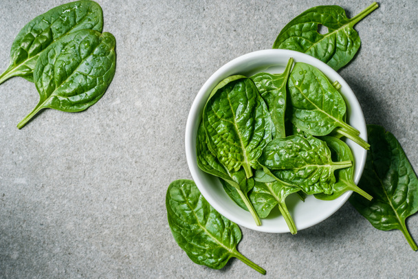 Top view of wet spinach leaves in bowl - Foto, Imagem
