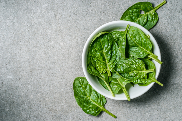 Top view of green spinach leaves in white bowl  - Photo, image