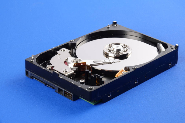 Unidade de disco rígido (HDD) isolado em um fundo azul
 - Foto, Imagem
