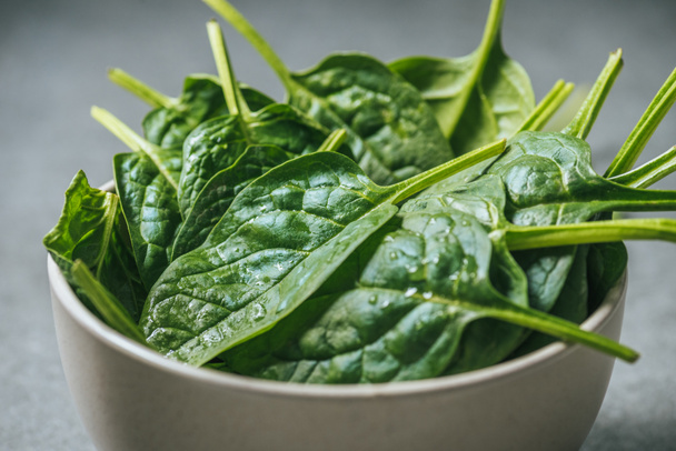 Organic fresh and wet spinach leaves in white bowl - Photo, image