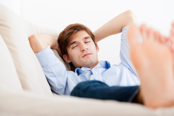 Man lying down on sofa - Fotó, kép