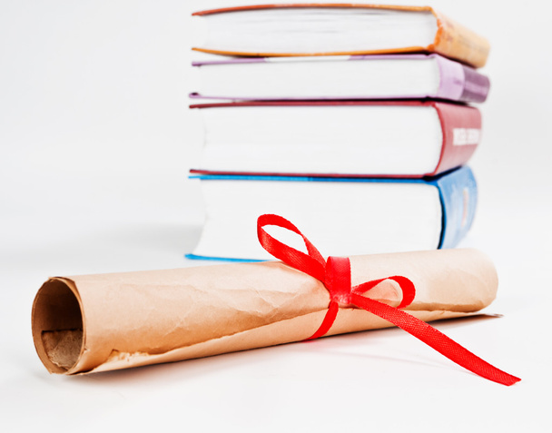Diploma with red ribbon and books - Фото, изображение