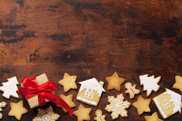 Різдвяна листівка з імбирним печивом та подарункова коробка на дерев'яному фоні. Вид зверху з пробілом для ваших привітань. Плоский прошарок
 - Фото, зображення