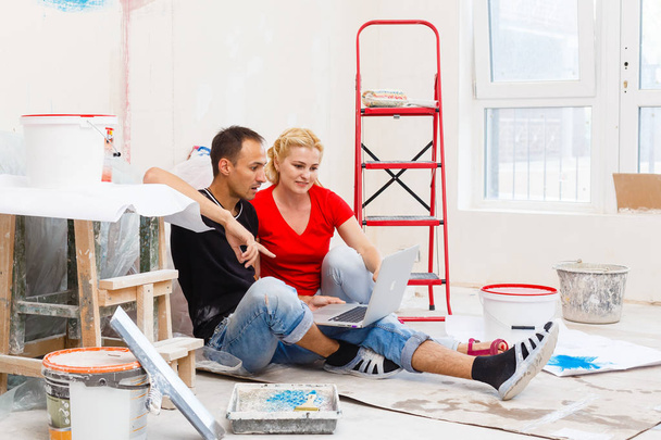 junges Paar repariert Wohnung und benutzt Laptop - Foto, Bild