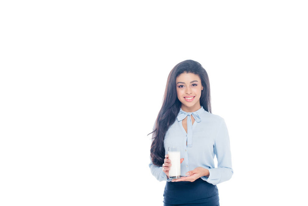 beautiful young african american woman holding glass of milk and smiling at camera isolated on white  - Φωτογραφία, εικόνα