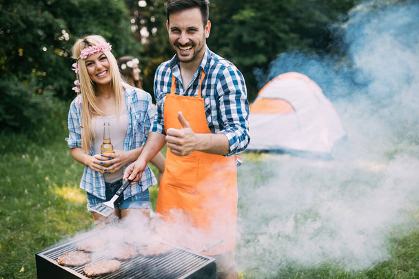 Young beautiful woman and handsome man having barbecue - 写真・画像